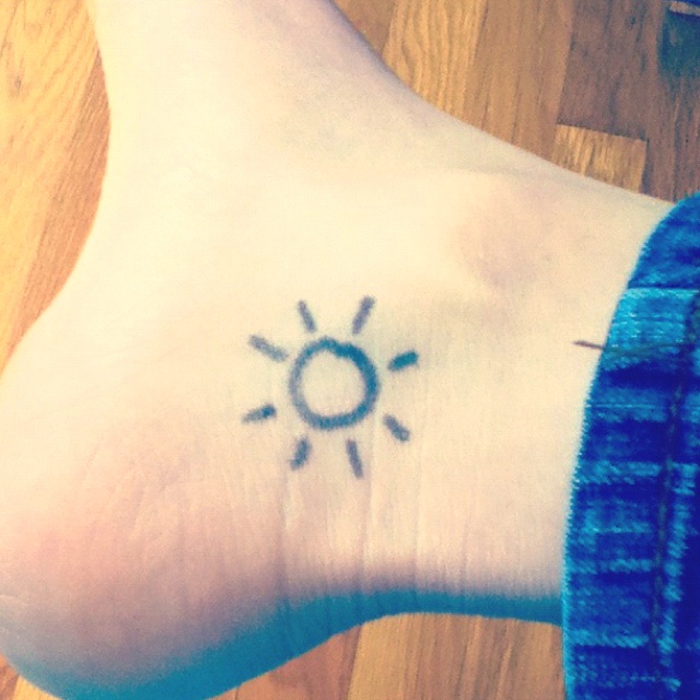 Black lovely sun tattoo on leg