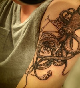 Black octopus and bicycle tattoo on arm