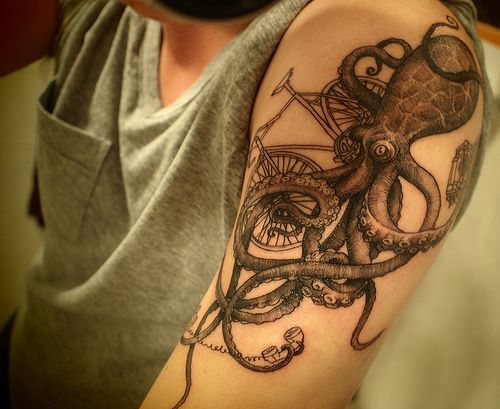 Black octopus and bicycle tattoo on arm