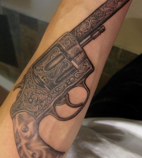 Black ornaments and gun tattoo