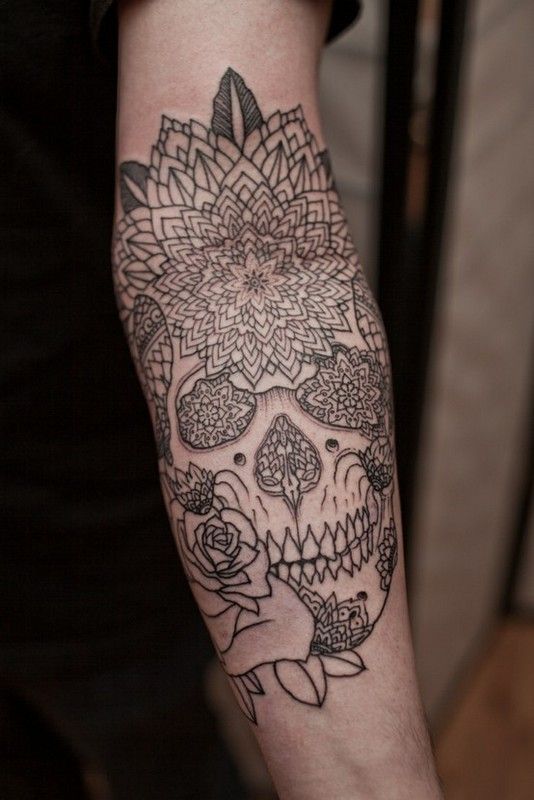 Black ornaments and rose skull tattoo on arm
