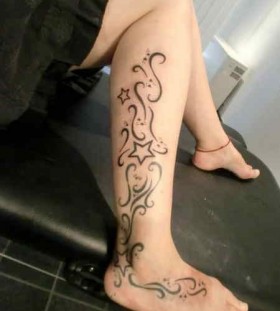 Black ornaments and star tattoo on leg