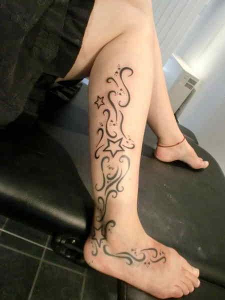 Black ornaments and star tattoo on leg