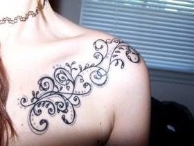 Black ornaments and star tattoo on shoulder