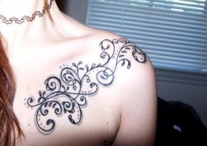 Black ornaments and star tattoo on shoulder