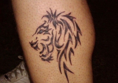 Black ornaments of lion tattoo on leg