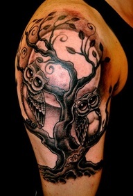 Black owl and tree tattoo on arm