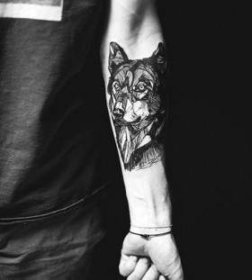 Black painted wolf tattoo on arm