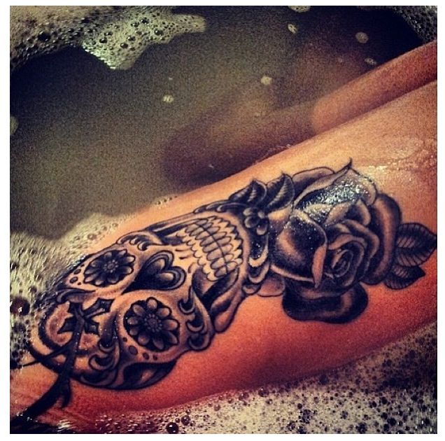 Black rose and skull tattoo on leg