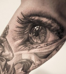 Black sculpture and eye tattoo on arm
