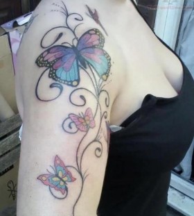 Black shoulder butterfly tattoo on arm