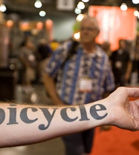 Black simple bicycle tattoo on arm