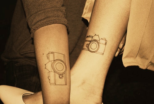 Black sketch camera tattoo on arm