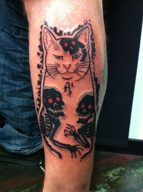 Black skull and cat tattoo on leg