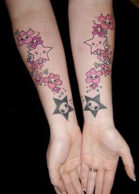 Black skulls and pink cherry tattoo on arm