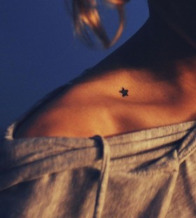 Black small star tattoo on shoulder