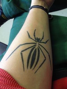 Black spider tattoo on arm