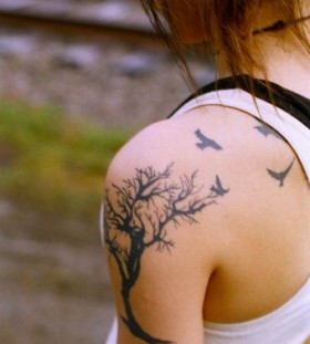 Black tree and bird tattoo on shoulder