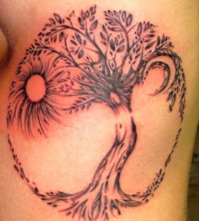 Black tree sun tattoo on leg