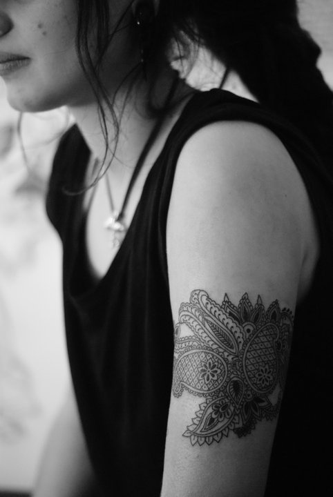 Black women’s lace tattoo on arm