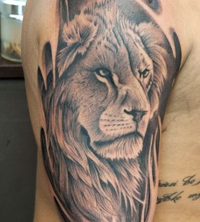 Black words and lion tattoo on leg