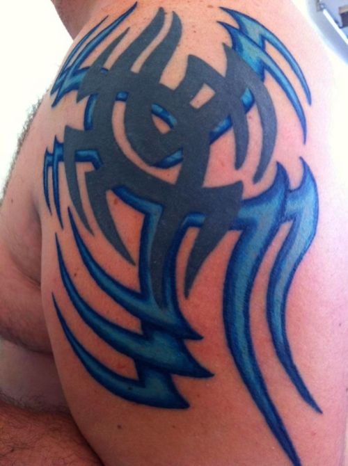 Blue and black tribal tattoo on shoulder