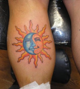 Blue and yellow sun tattoo on leg