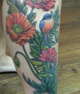 Blue bird and poppy tattoo on leg