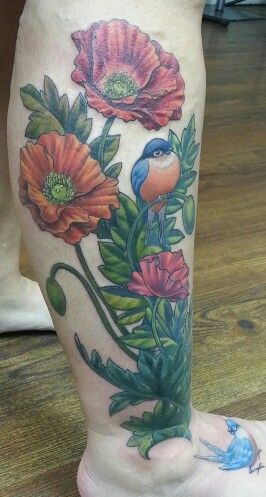 Blue bird and poppy tattoo on leg
