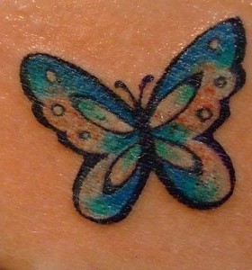 Blue butterfly tattoo on shoulder