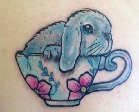 Blue cup and rabbit tattoo on body