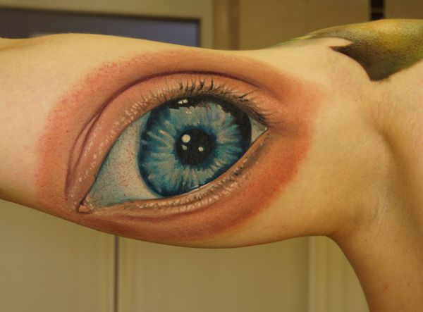 Blue men’s eye tattoo on arm