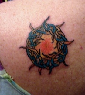 Blue, red sun tattoo on shoulder