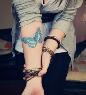 Blue simple butterfly tattoo on arm