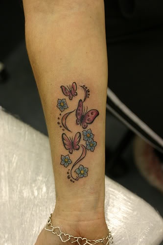 Blue small butterfly tattoo on arm