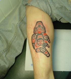 Boy's black and red fish tattoo on leg