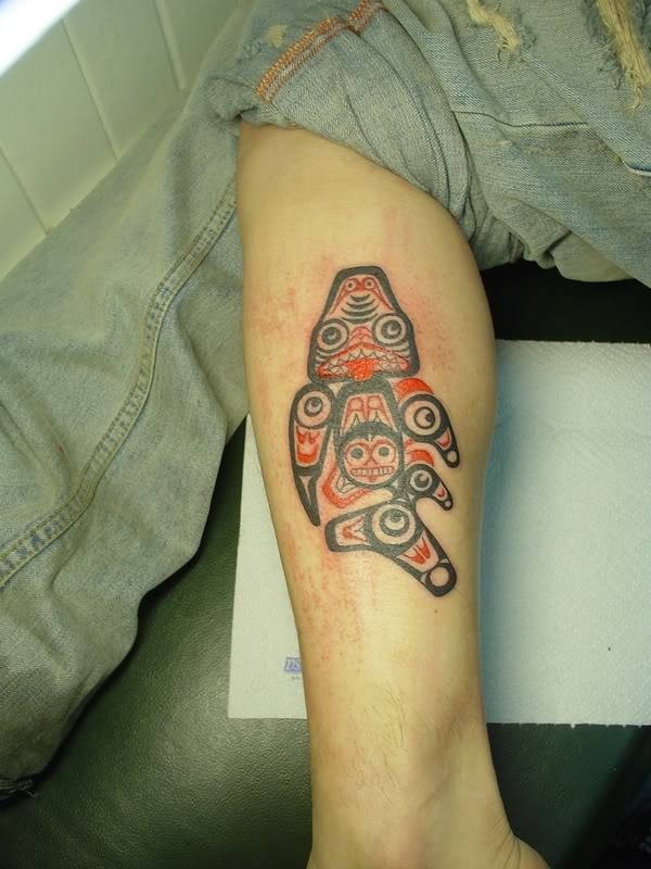 Boy’s black and red fish tattoo on leg