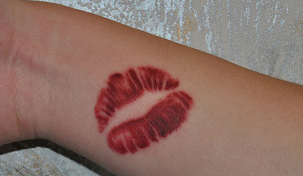 Bright red lips tattoo on arm