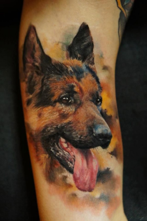 Brown and black dog tattoo on arm