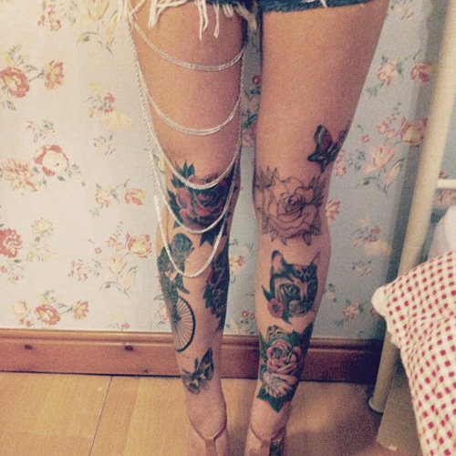 Cat, bike and red rose tattoo on leg