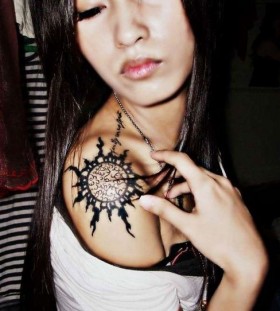 Chinese girl's sun tattoo on shoulder
