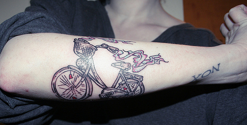 Colorful black bicycle tattoo on arm