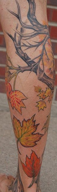 Colorful leafs and tree tattoo on leg