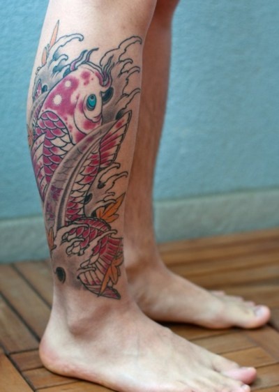 Colorful red fish tattoo on leg