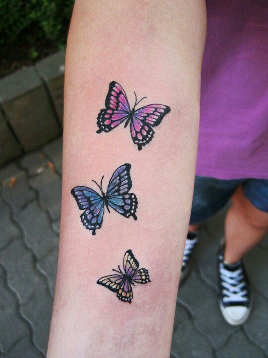 Colorful small butterfly tattoo on arm
