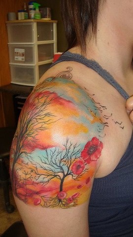 Colorful women’s tree tattoo on shoulder