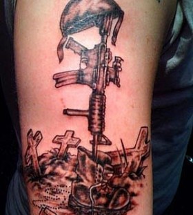Cross and black soldier tattoo on arm