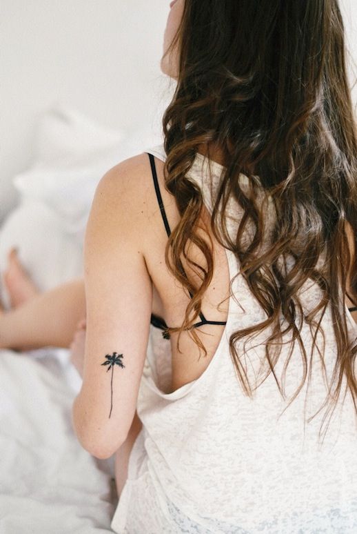 Curly hair girl tree tattoo on arm