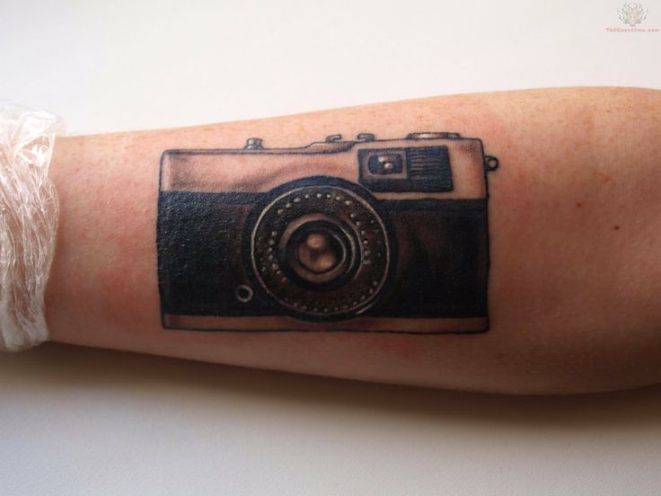 Cute black camera tattoo on arm