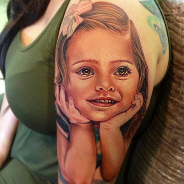 Cute girl face tattoo on arm
